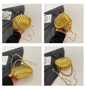 Detail of golden shell evening clutch bag with beaded handle and metallic stripe finish
