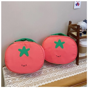 Close-up of cute red tomato shaped nylon makeup bags with green leaf handles and smiley faces