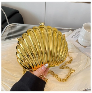 Detail of a golden shell evening clutch with metallic texture and chunky chain strap