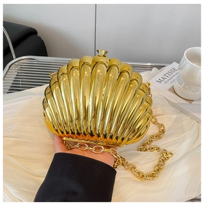 Detailed view of a golden shell-shaped evening clutch bag with metallic chain