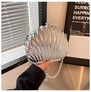 Close-up of silver shell-shaped evening bag with metallic texture and chunky chain strap