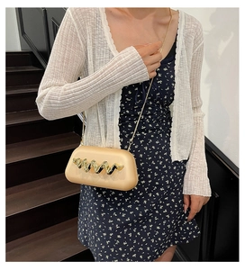Pochette crème chic avec décor doré ondulé et fine bandoulière chaîne portée en travers