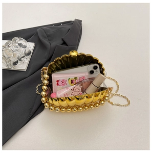 Detail of gold shell evening bag interior showing storage for phone and cosmetics