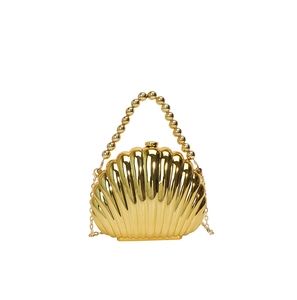 Detail of a golden shell evening bag featuring a pearl handle and chic metal chain strap