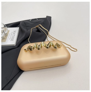 Détail de la pochette de soirée champagne avec poignée en métal et bandoulière chaîne