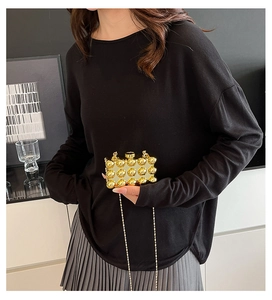 Detail showing high-end golden acrylic sphere mini bag with textured 3D stud finish