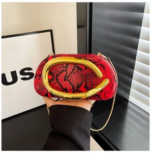 Détail du sac de soirée serpent rouge avec une grande poignée dorée et une chaînette