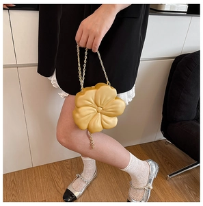 Detail view of yellow acrylic 3D flower evening bag with elegant golden chain strap