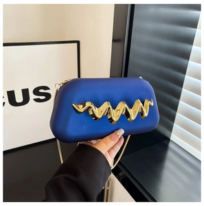 Détail de la pochette de soirée bleue avec poignée dorée et bandoulière en chaîne
