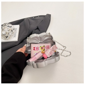 Silver shell-shaped clutch bag showing inner capacity with lipstick and wallet