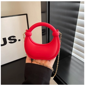 Dettaglio borsa rossa in silicone con manico a nodo e catena dorata rimovibile