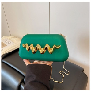 Détail de la pochette de soirée vert émeraude avec décorations dorées et fine chaîne