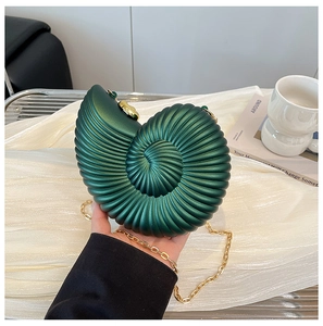Dettaglio della borsa da sera a conchiglia verde scuro con catena dorata e spirale