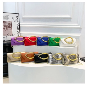 Macro view of envelope clutch bags in diverse colors with gold crescent handles and chains