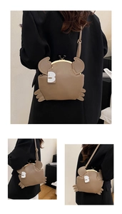 Detail view of khaki crab-shaped crossbody bag featuring vintage gold clasp and crab claws