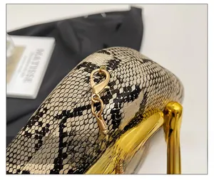 Détail de la pochette en acrylique imprimé serpent avec finitions dorées et bandoulière