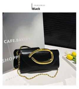 Macro shot of black leather clutch bag with luxury oversized gold oval metal buckle detail