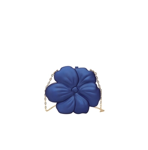 Close-up of dark blue acrylic flower evening bag with elegant gold metal chain strap