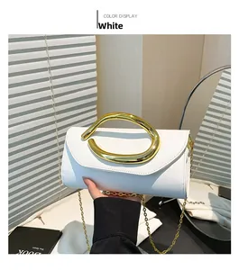 Close-up of a white leather evening clutch with a bold golden streamlined metal handle