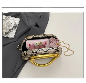 Détail montrant la capacité intérieure du sac de soirée serpent avec chaîne dorée