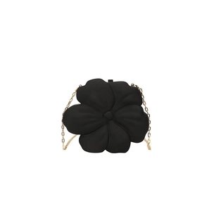 Detail of creative black flower evening clutch bag with elegant golden chain strap