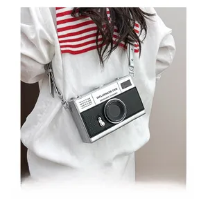 Detail of camera-shaped crossbody bag with silver frame and black lychee leather texture