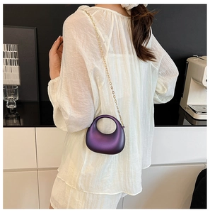 Sac croissant en acrylique violet métallisé avec chaîne dorée porté par un mannequin
