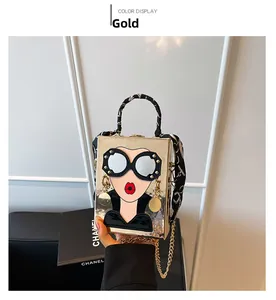 Detail of gold acrylic clutch with 3D cartoon face design and silk scarf handle