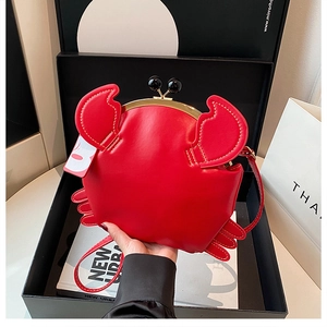Detailed view of red crab-shaped creative bag with gold metal clasp and leather strap