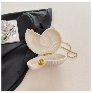 Elegante borsa a conchiglia con catena dorata su un tavolo in stile minimalista