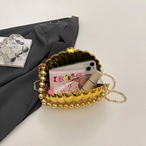 Golden acrylic shell evening bag with metallic finish, top handle, and chain strap