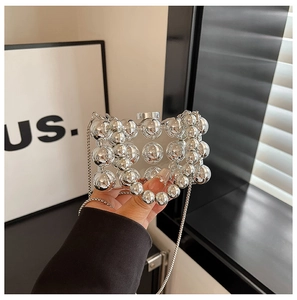 Detail of mini pearl style evening bag with polished silver spheres and chain strap