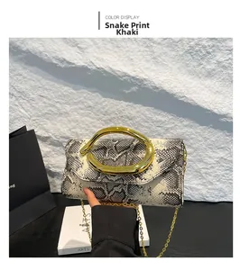Detail of snake pattern clutch bag with large gold ring handle and metal chain