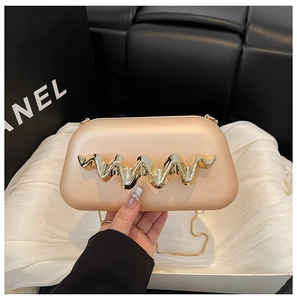 Détail d'une pochette de soirée champagne doré avec accent métallique ondulé et chaîne