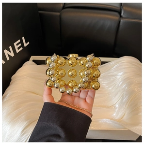 Macro shot of geometric gold and silver spheres on acrylic evening bag with chain