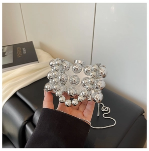 Macro view of silver mirrored beads and metallic chain on the acrylic evening bag