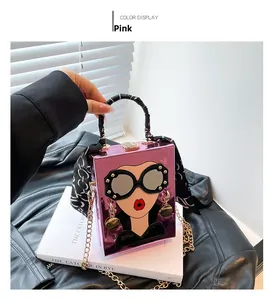 Close-up of pink pop art handbag with sunglasses face design and decorative silk scarf