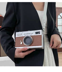 Detail of camera-shaped crossbody bag with silver and brown faux leather patchwork design