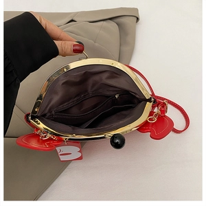Detailed interior of red crab-shaped handbag showing kiss-lock clasp and zipper pocket