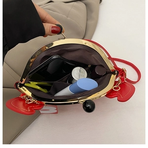 Internal view of a red crab-shaped handbag showing storage space and metal frame