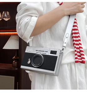 Detail of creative camera-shaped crossbody bag with silver and black textured leather