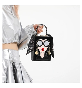 Detail of square pop art handbag featuring a silk scarf handle and sequin earrings