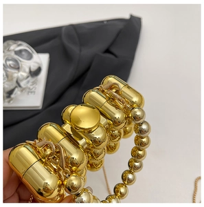 Detailed close-up of the polished gold metallic bead structure of this designer mini bag