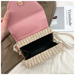 Détail du sac en paille avec rabat en cuir rose, fermoir magnétique et bandoulière
