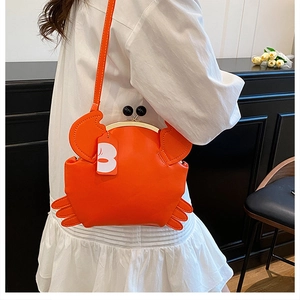 Detail of creative orange crab crossbody bag with metal kiss-lock and leather texture