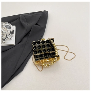 Detail of gold metallic bubble texture mini bag with pearl handle and chain strap
