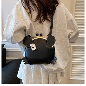 Detailed back view of a creative black crab-shaped crossbody bag with golden clasp