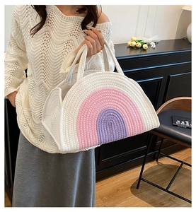 Detailed texture of cotton rope storage bag with pink and purple rainbow woven stripes