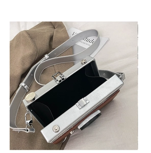Macro shot showing internal space of silver camera-shaped crossbody bag with metal buckle
