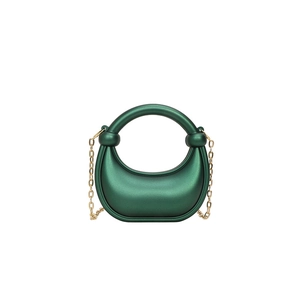 Dettaglio della borsa clutch in acrilico verde scuro con manico tondo e catena